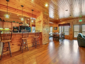 Un intérieur en bois comprenant un bar, un espace repas et un canapé.