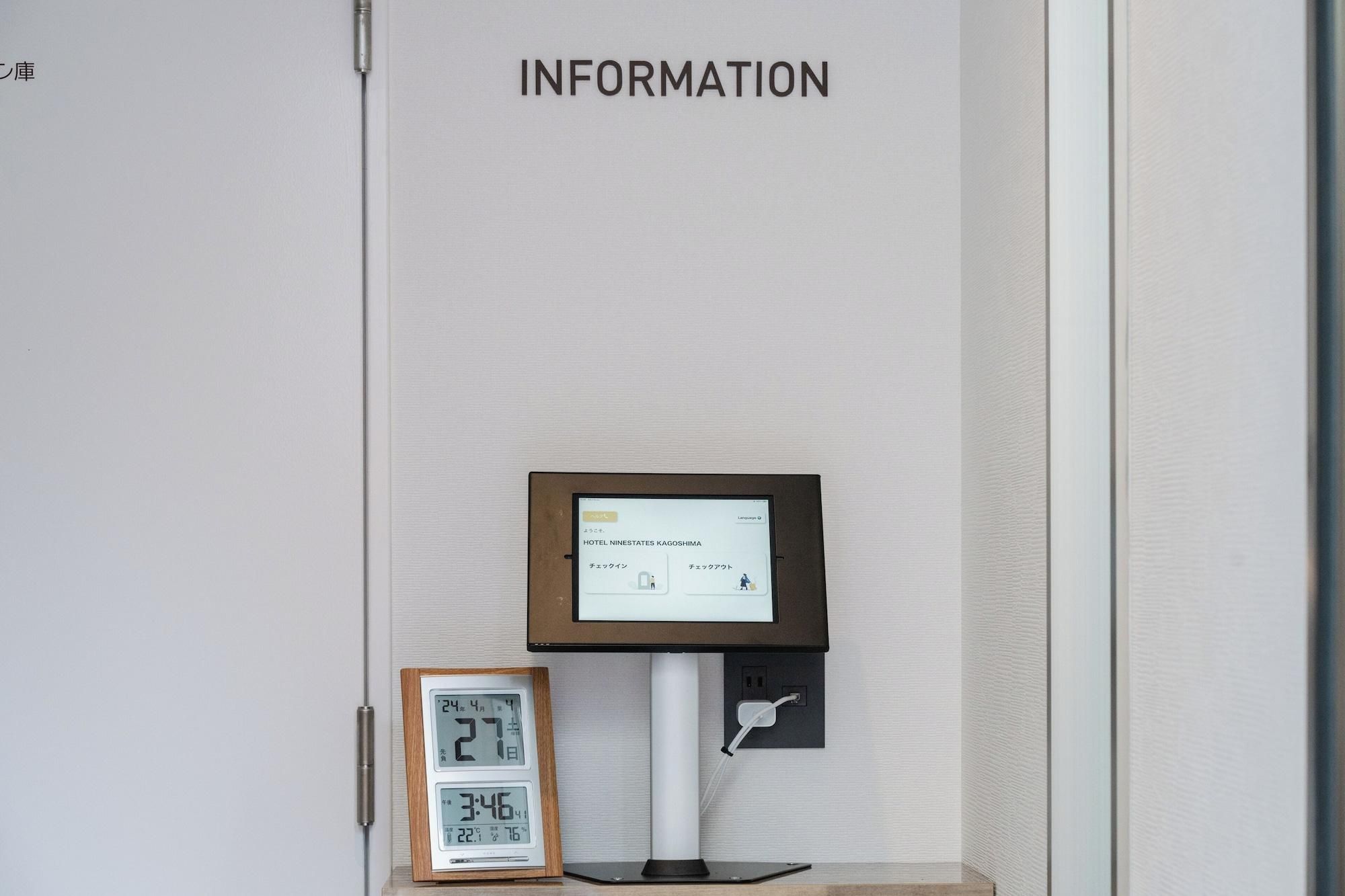 Un quiosco digital informativo con una pantalla que muestra detalles del hotel, un reloj y un letrero superior que dice 'INFORMATION'.