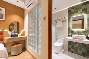 Une salle de bain moderne avec un grand miroir, des toilettes et un lavabo.