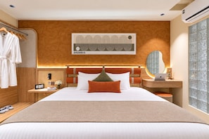 Une chambre d’hôtel avec un grand lit, une table de chevet avec un ordinateur portable, une œuvre d’art accrochée au mur et une fenêtre avec du verre décoratif.