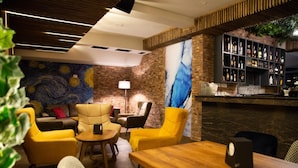 A bar area with seating and a wall with a blue abstract painting. - Hotel City In (Kocani)