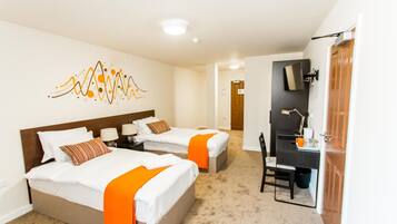 A hotel room with two beds, a desk, a chair, and a television.