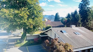 A residential building with a sloped roof, a visible chimney, and a parking area with cars. - Hotel Sternen Worb (Worb)