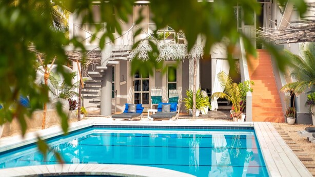 Una piscina con sillas de descanso y una escalera que conduce a una zona cubierta.