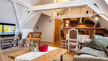 Een gezellig loft-appartement met een eetgedeelte, keuken en televisie.