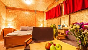 A wooden room with a bed, a desk, and a table with fruit. - Debeli Dab (Kresna)