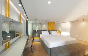 A modern hotel room with a large bed, bedside tables, a seating area, and a large mirror. - Dorchester Hotel (Ksamil)