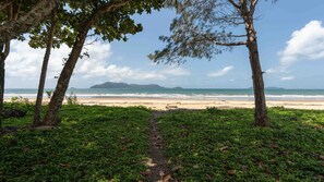 A beach path leading to a sandy beach with ocean views, surrounded by trees and greenery. - Sea Views on Kennedy (South Mission Beach)