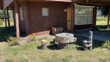 Una construcción rústica de madera con revestimiento de espiga, una puerta de madera y una ventana de cuadrícula.