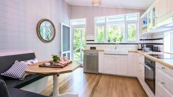 Una cocina moderna con armarios blancos, encimera de madera y lavavajillas integrado.