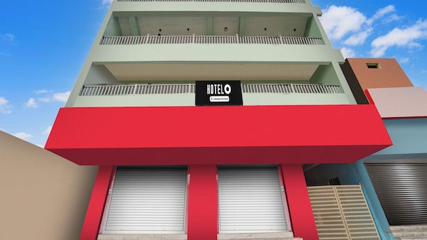 Un edificio a più piani con facciata rosso e beige, balconi su ogni piano e una insegna che indica che si tratta di un hotel di servizio aziendale.