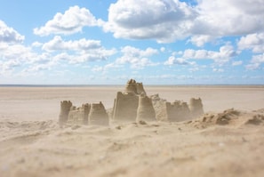 Paisagem desértica com formações de areia que lembram ruínas antigas.