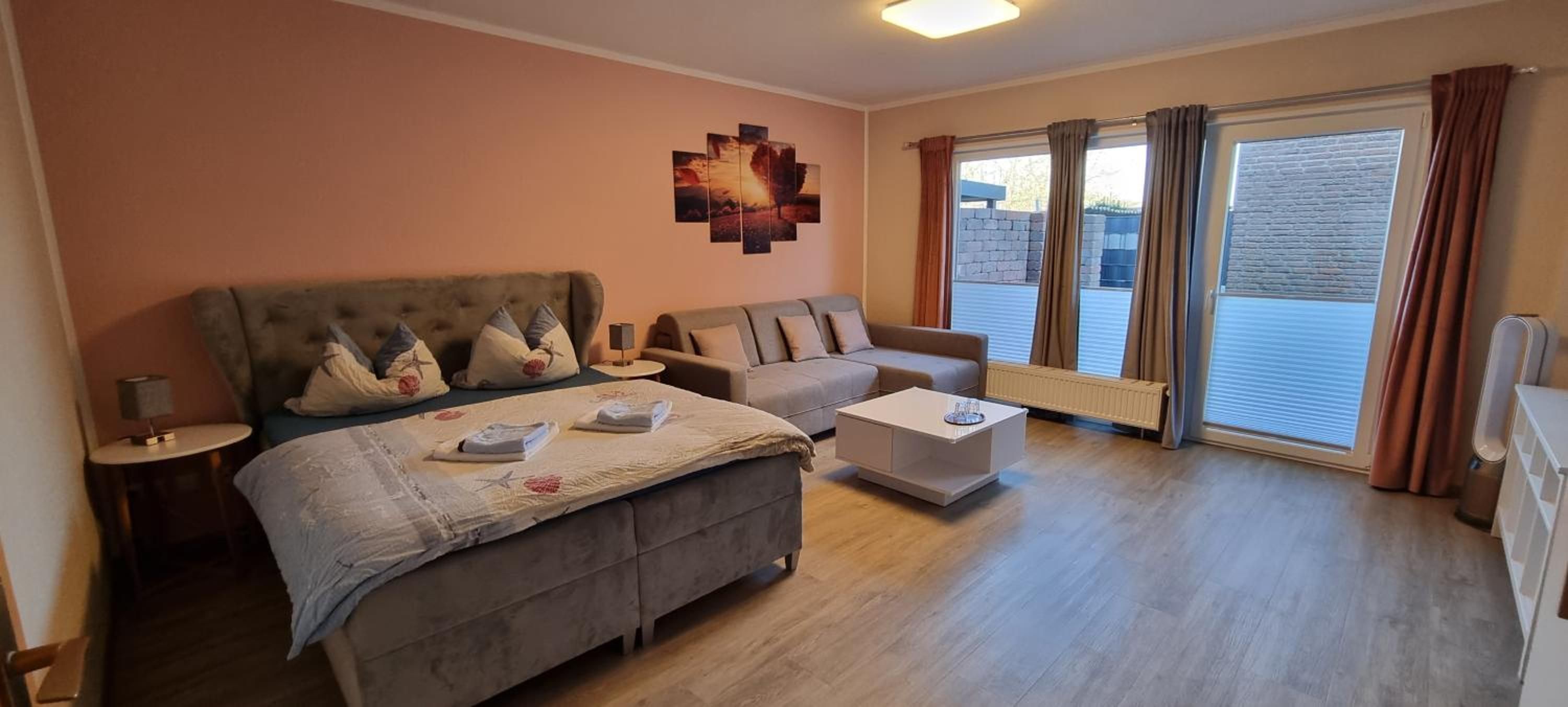 Ein Hotelzimmer mit einem Bett, einem Sofa, einem Couchtisch und einem Vorhangfenster.