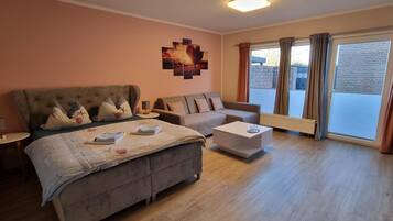 Ein Hotelzimmer mit einem Bett, einem Sofa, einem Couchtisch und einem Vorhangfenster.