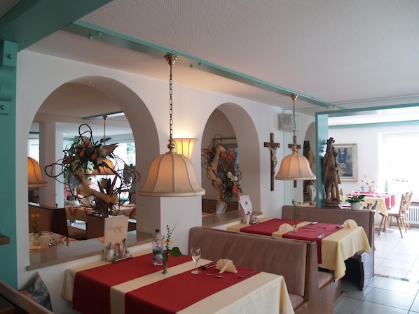 A restaurant with booths and tables, arched ceilings, and hanging lamps. - Best Breakfast - Hotel Justina (Bad Woerishofen)