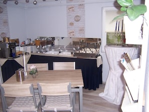 A buffet setup with various food stations, a coffee bar, and a dining area with tables and chairs. - Gästehaus Schneider (Bechtheim)