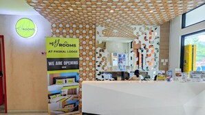 A reception desk with a modern design, a sign indicating the property is at Paskal Lodge, and a display of room types. - My Room at Paskal Hypersquare (Kota Bandung)