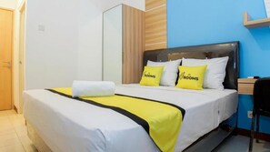 Ein Hotelzimmer mit Bett, Nachttisch, Stuhl und Kleiderschrank.