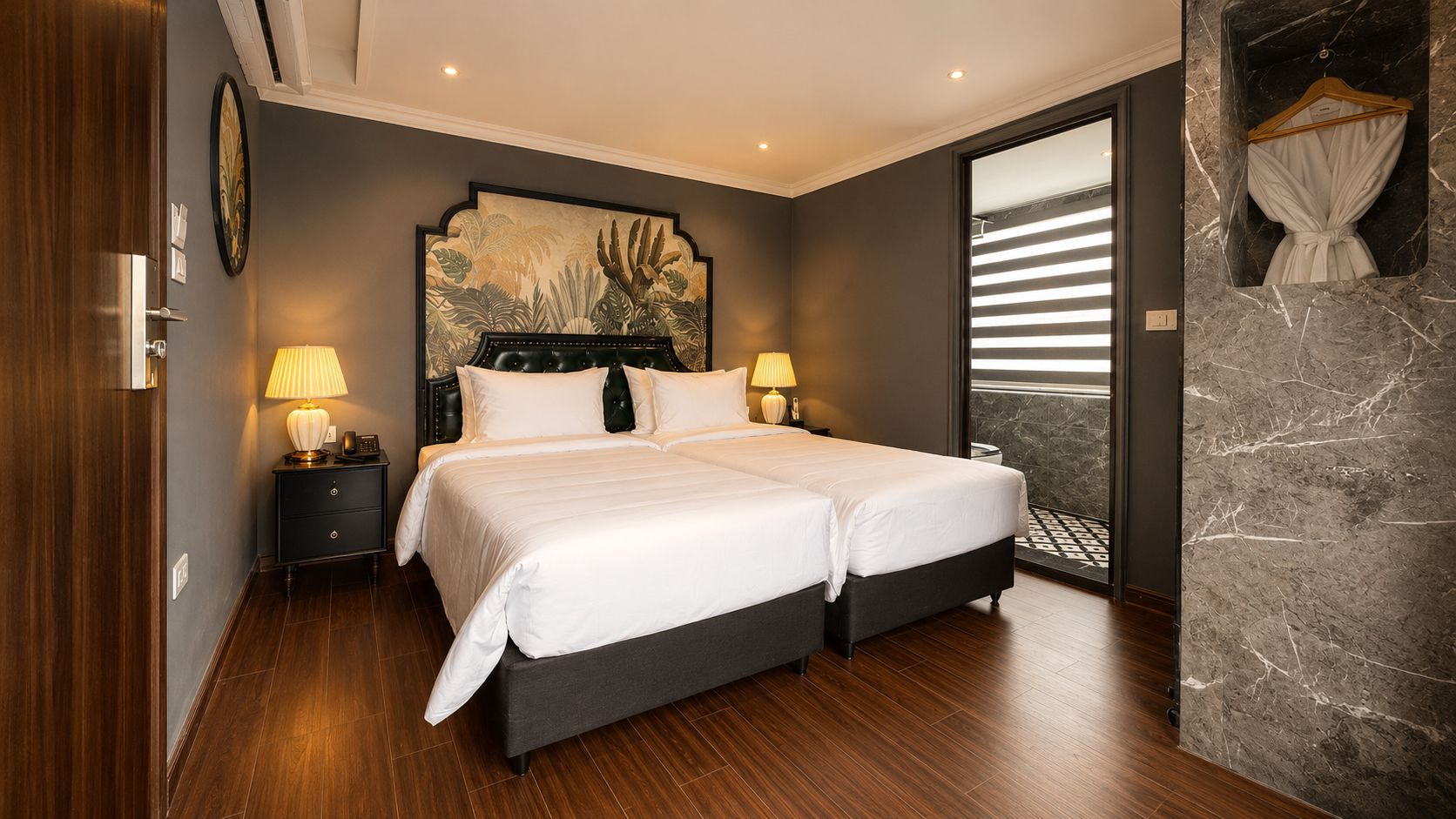 A double bed with a dark headboard, two bedside tables with lamps, and a large window with blinds.