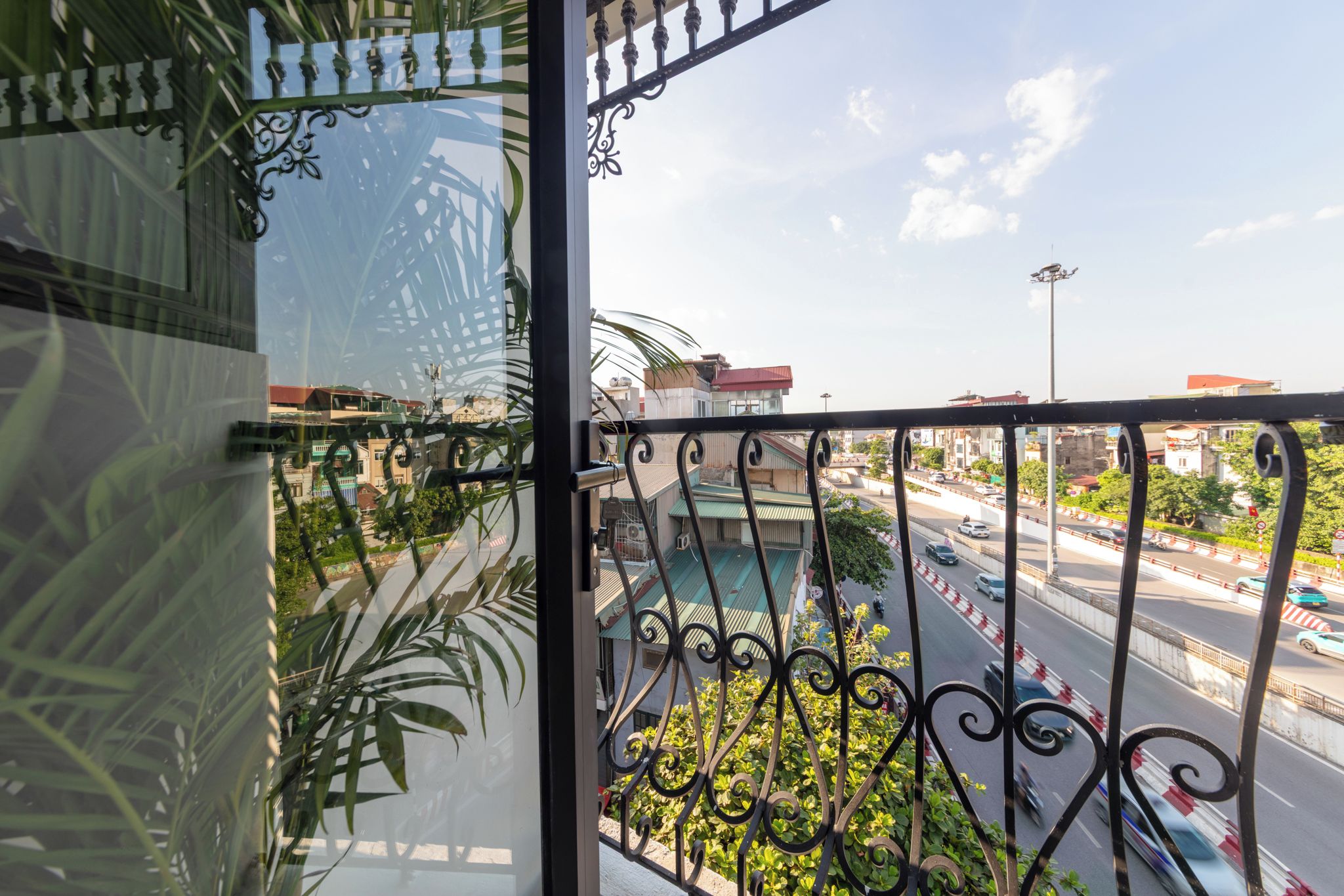 Ein Balkon mit Blick auf eine belebte Straße und Gebäude.