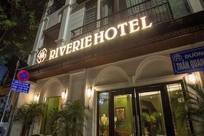 The exterior of the Riverie Hotel with a prominent illuminated sign, a no parking sign, and a sign indicating Duong Tran Quan. - Premium Madelis Hotel (Hanoi)