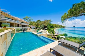 A modern resort with a large pool, a beach, and a clear view of the ocean. - Amarna Luxury Beach Resort (Nelson Bay)