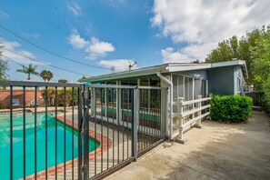 A residential property with a swimming pool, a covered patio, and a fenced area. - LongBeach Cottage - Pool, Spa, Games, 4Miles2Beach (Long Beach)