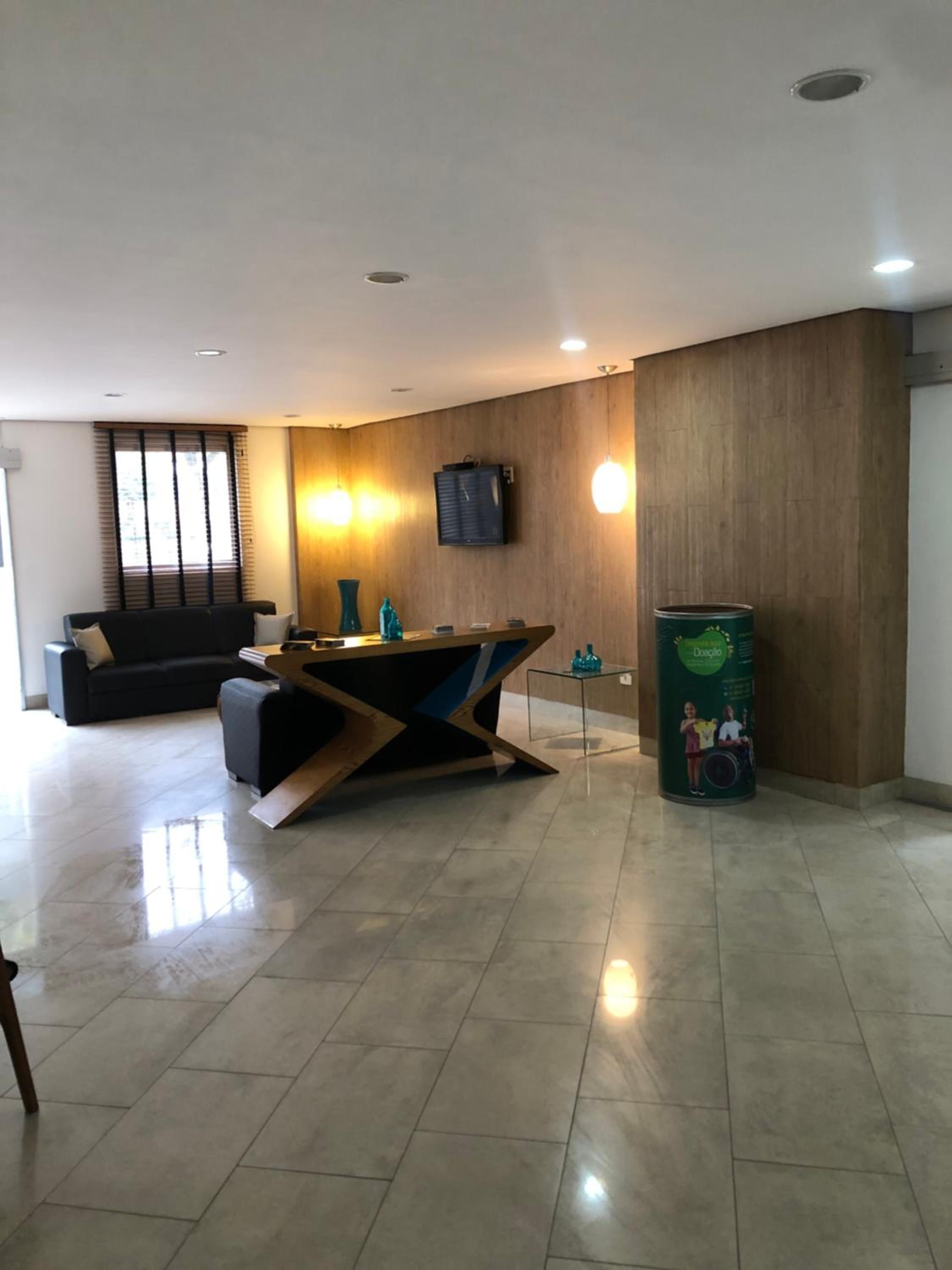 A modern interior with a reception desk, a sofa, and a trash can.