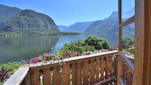 Uma varanda com vista para um lago e montanhas.
