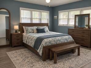 Un dormitorio con una cama de madera, una mesita de noche, un aparador y un espejo.