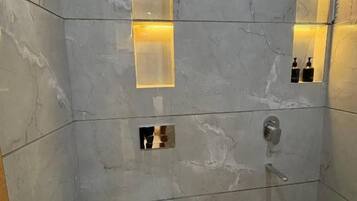 Et moderne badeværelse med toilet, bidet og bruseområde.
