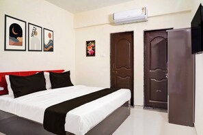 Habitación de hotel con cama, armario, puerta y aire acondicionado de pared.