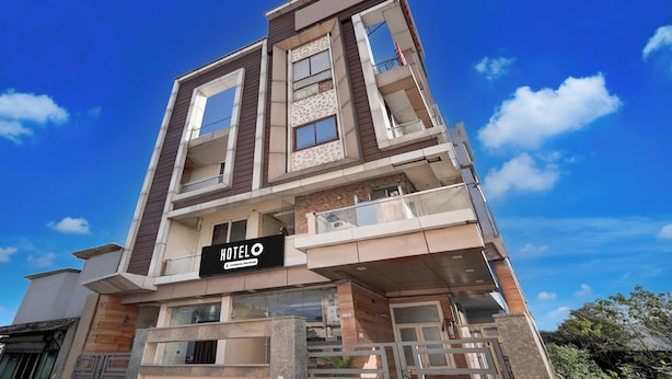 A multi-story hotel with a modern design, featuring balconies and large windows. - Super Hotel O GMS Road Formerly The Nest (DEHRADUN)