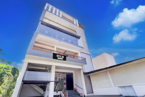 A multi-story hotel with a sign indicating it is a company-serviced establishment. - Super Hotel Nagamalaipudukottai Madurai (Madurai)