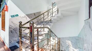 Una escalera con barandilla metálica y un letrero de salida de incendios.