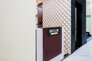 A hotel entrance with a sign indicating it is company-serviced.
