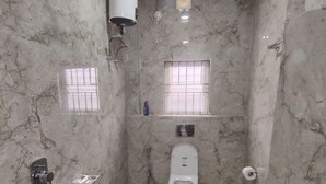 Ein Badezimmer mit Toilette, Dusche und einem Händetrockner.