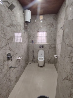 Ein Badezimmer mit Toilette, Dusche und einem Händetrockner.