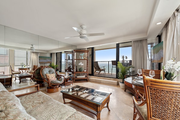 A spacious living area with a large window, a ceiling fan, and a balcony with a view of the ocean. - Oceanfront 1BD with Unobstructed Ocean, Lanai & Island Views & Pool -Kaleialoha 415 (Lahaina)