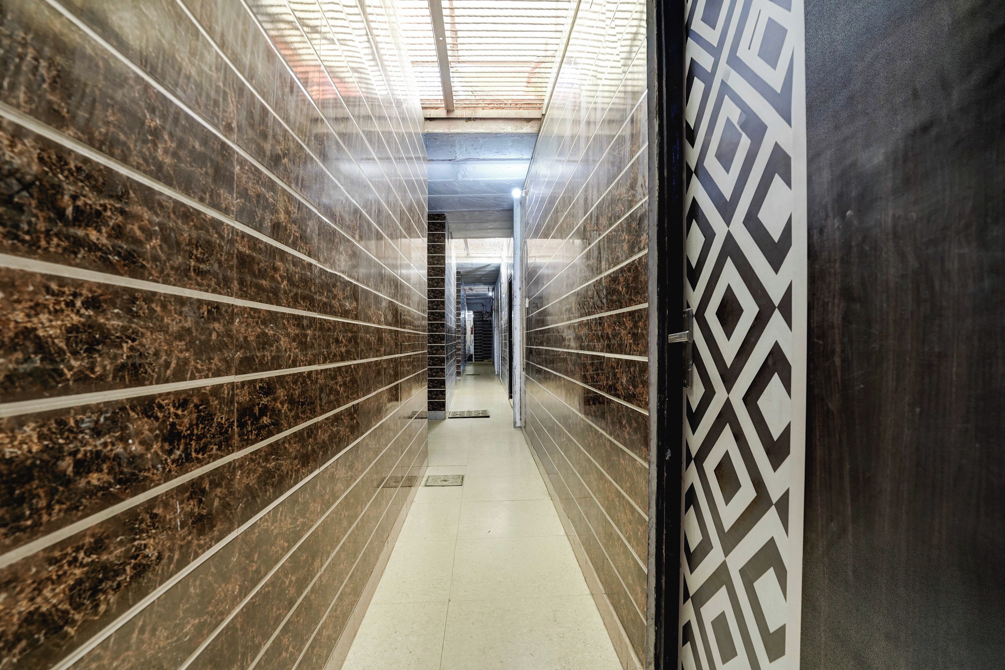 A corridor with tiled walls and a patterned door.