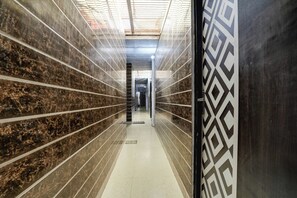 A corridor with tiled walls and a patterned door. - Hotel O Hindon Airport Ghaziabad (Ghaziabad)