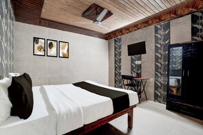 A bedroom with a bed, a ceiling fan, a flat-screen TV mounted on the wall, and framed artwork above the bed. - Hotel O Hindon Airport Ghaziabad (Ghaziabad)