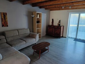 Ein Wohnzimmer mit einer Couch, einem Holzschrank und einem Couchtisch.