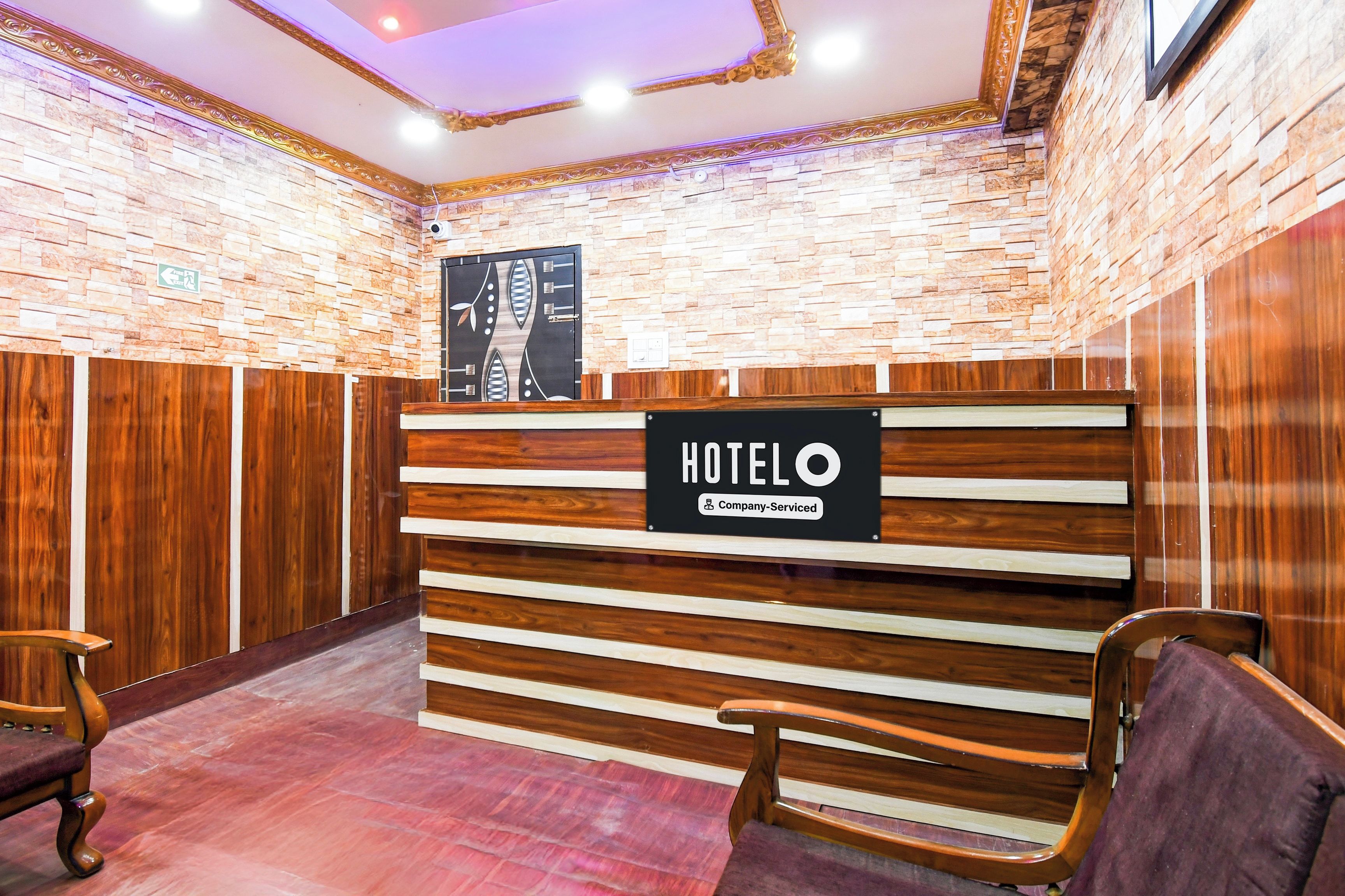 A hotel reception desk with a sign that reads 'HOTELO Company-Serviced.'