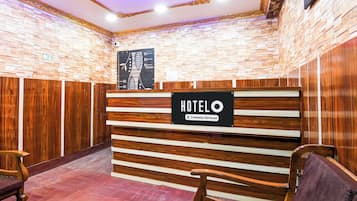 A hotel reception desk with a sign that reads 'HOTELO Company-Serviced.'