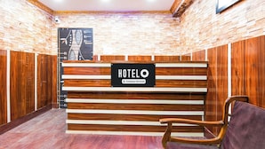 En hotellreception med en skylt som visar texten: ”HOTELO Company Serviced”.