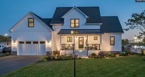 A two-story house with a front porch, a garage, and a well-maintained lawn. - Sea La Vie House wPool | The Inn on Turville Creek (Berlin)