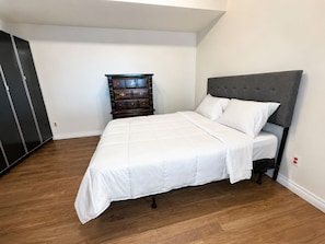 Ein Schlafzimmer mit einem Bett, einem Schminktisch und einem Kleiderschrank.