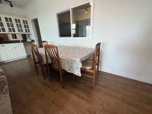 Ein Essbereich mit einem Tisch, vier Stühlen und einem Fenster.
