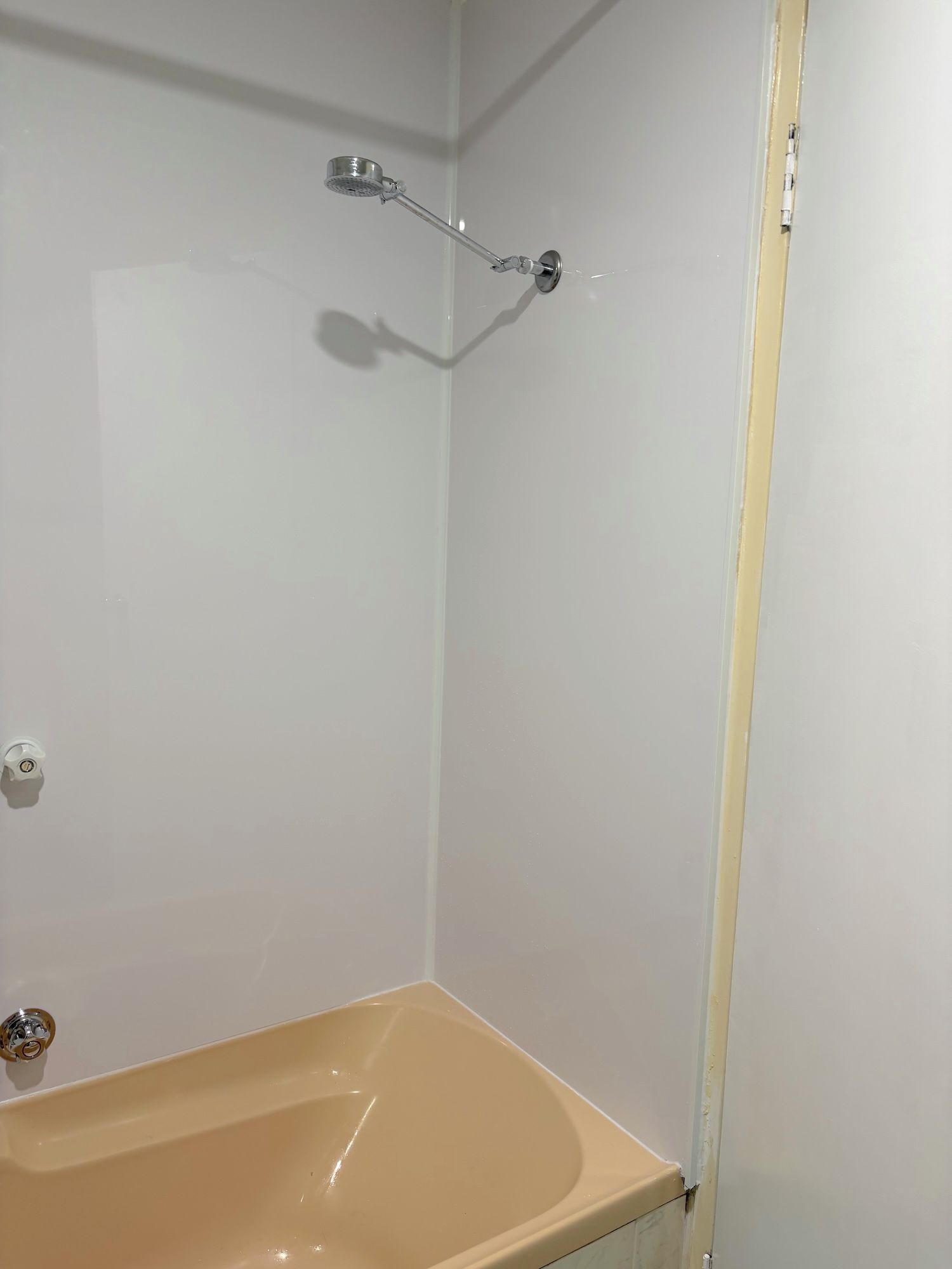 A bathroom with a bathtub, a showerhead, and a toilet.